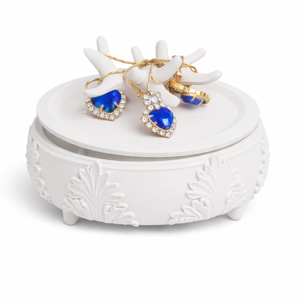 White jewelry box with blue heart-shaped earrings and gold rings on a white background