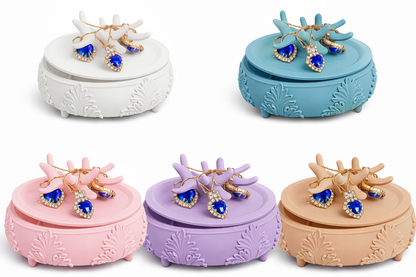 Set of five decorative jewelry boxes in different colors with earrings on top.