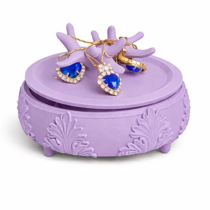 Purple jewelry box with heart-shaped blue earrings on a white background