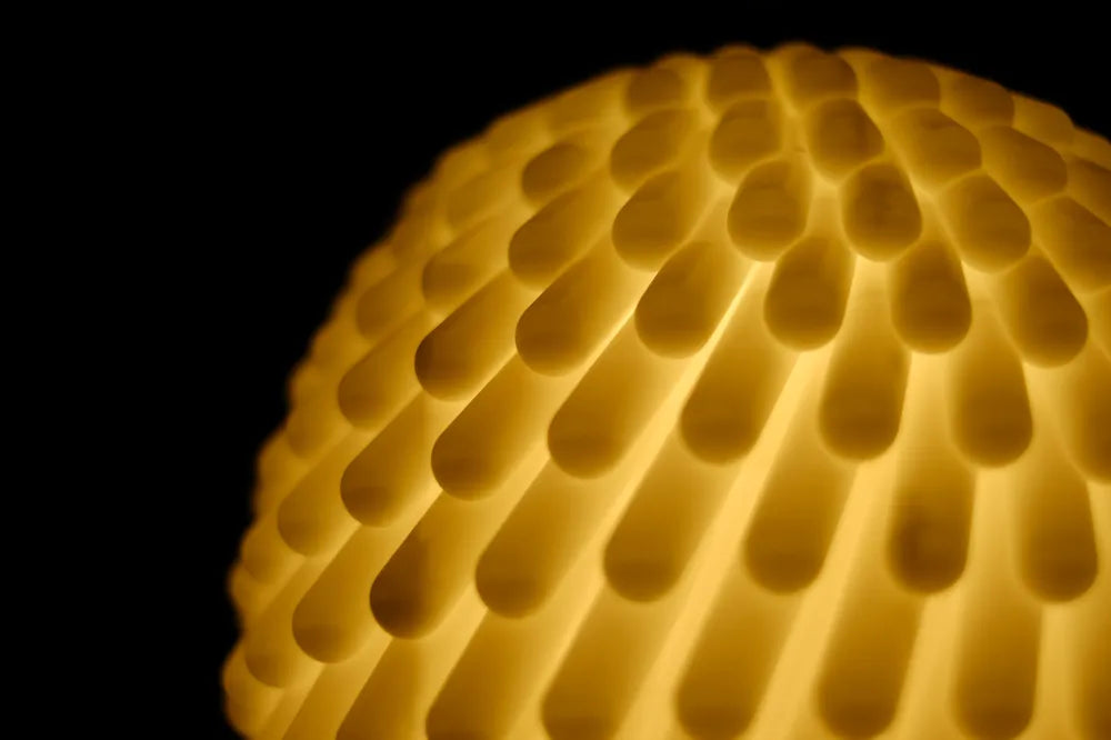 Close-up of a textured spherical object with a warm glow on a black background