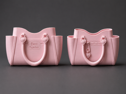 Two pink tote-style containers with integrated handles and side pockets, shown side by side on a dark gray background. The left one is embossed with the words 'Best Teacher'.