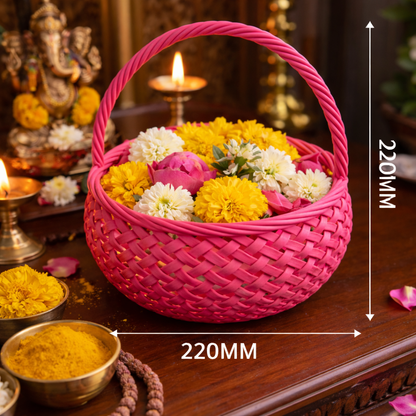 Pink woven basket with flowers on a wooden surface, surrounded by religious items.