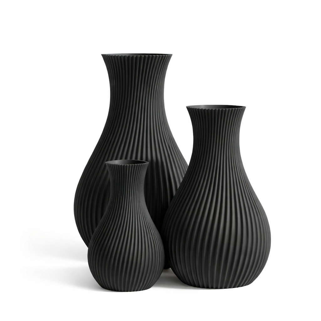 Set of three black ribbed vases on a white background