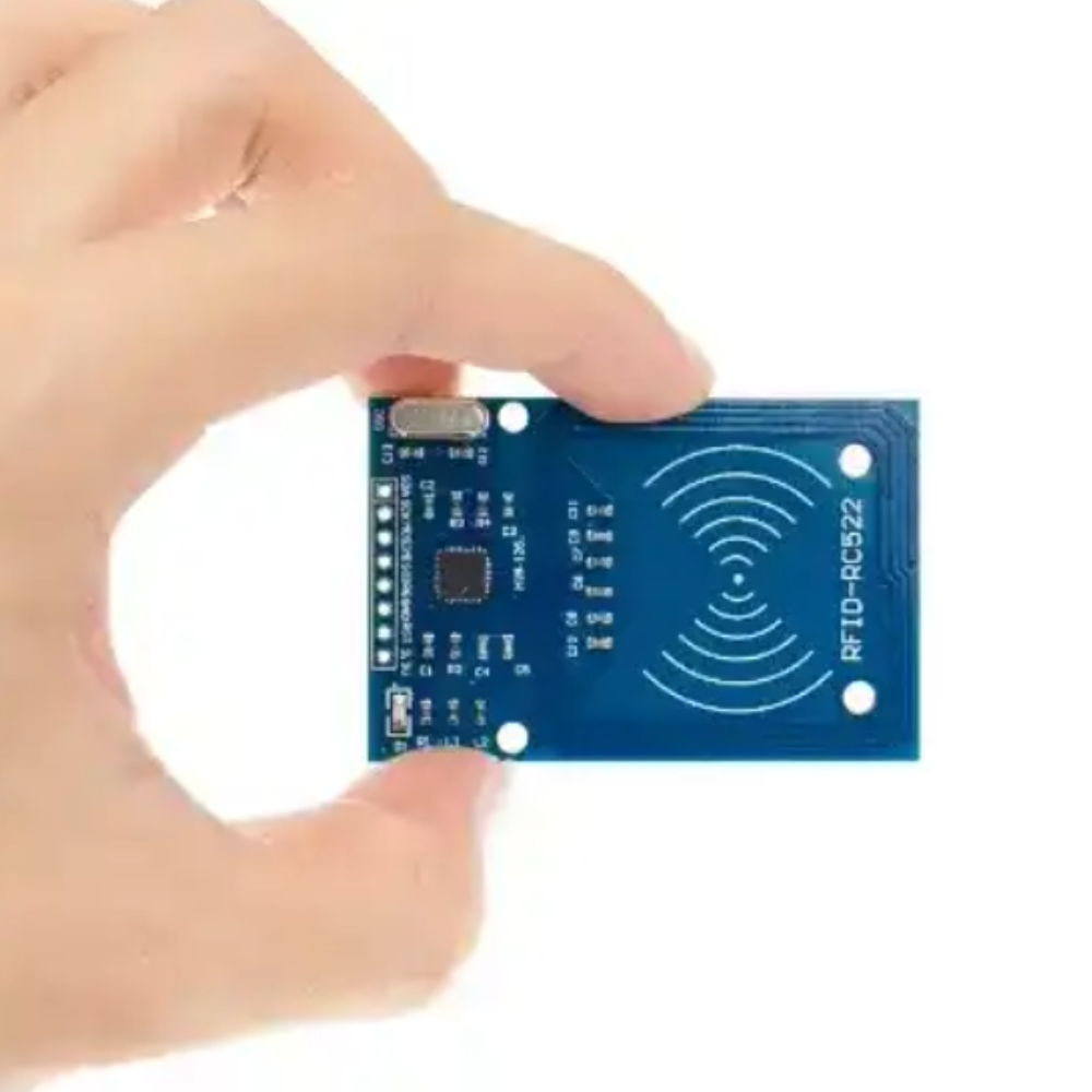 Hand holding a blue RFID module with a white background