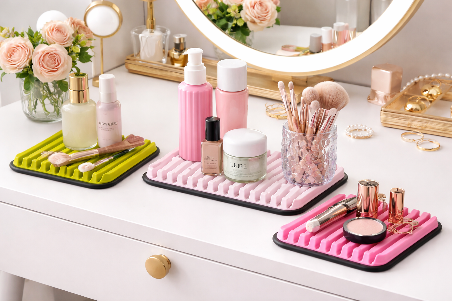 Makeup products on pink trays with a vanity setup including a mirror and flowers.