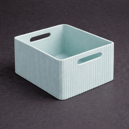Light blue storage basket with handles on a dark background