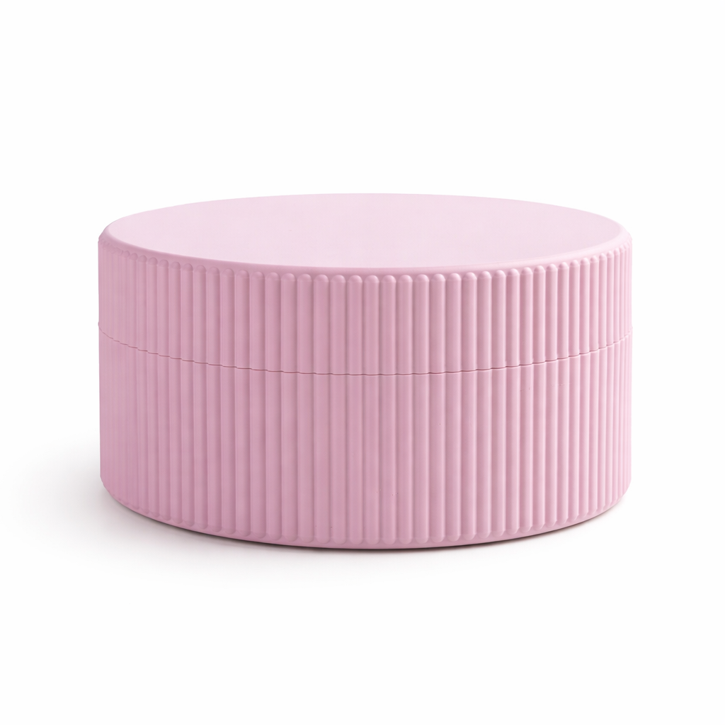 Pink cylindrical container with ribbed texture on a white background