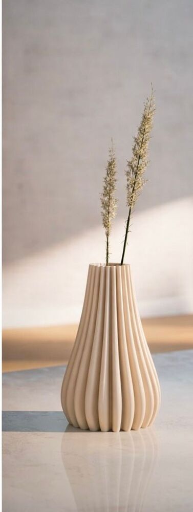 Beige textured vase with dried plants on a light background