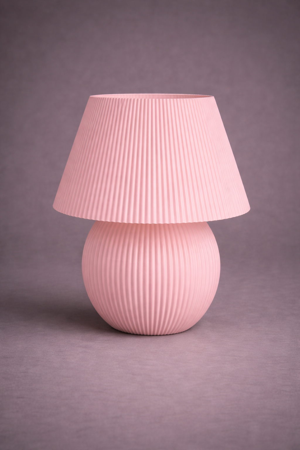 Pink textured table lamp on a gray background