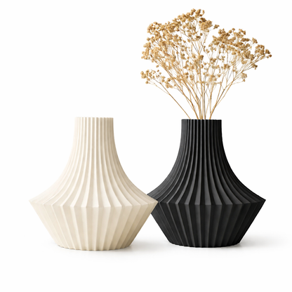 Two ribbed vases, one black and one beige, with dried flowers on a white background.