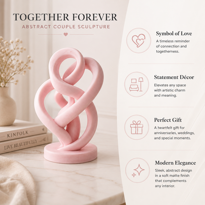 A pink abstract couple sculpture sits on a light marble surface beside stacked books, with promotional text on the right describing it as a symbol of love, statement decor, perfect gift, and modern elegance.