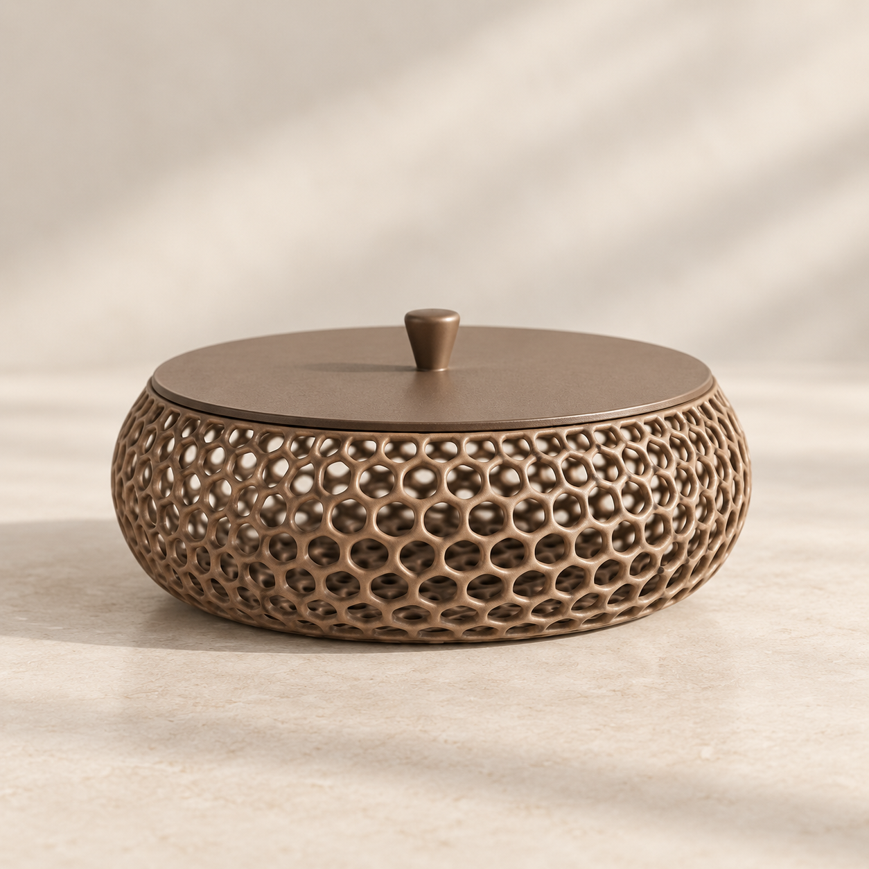 A round decorative container with a matching lid, featuring a textured honeycomb cutout pattern on the body and a small top knob, shown on a warm beige surface with soft shadows.