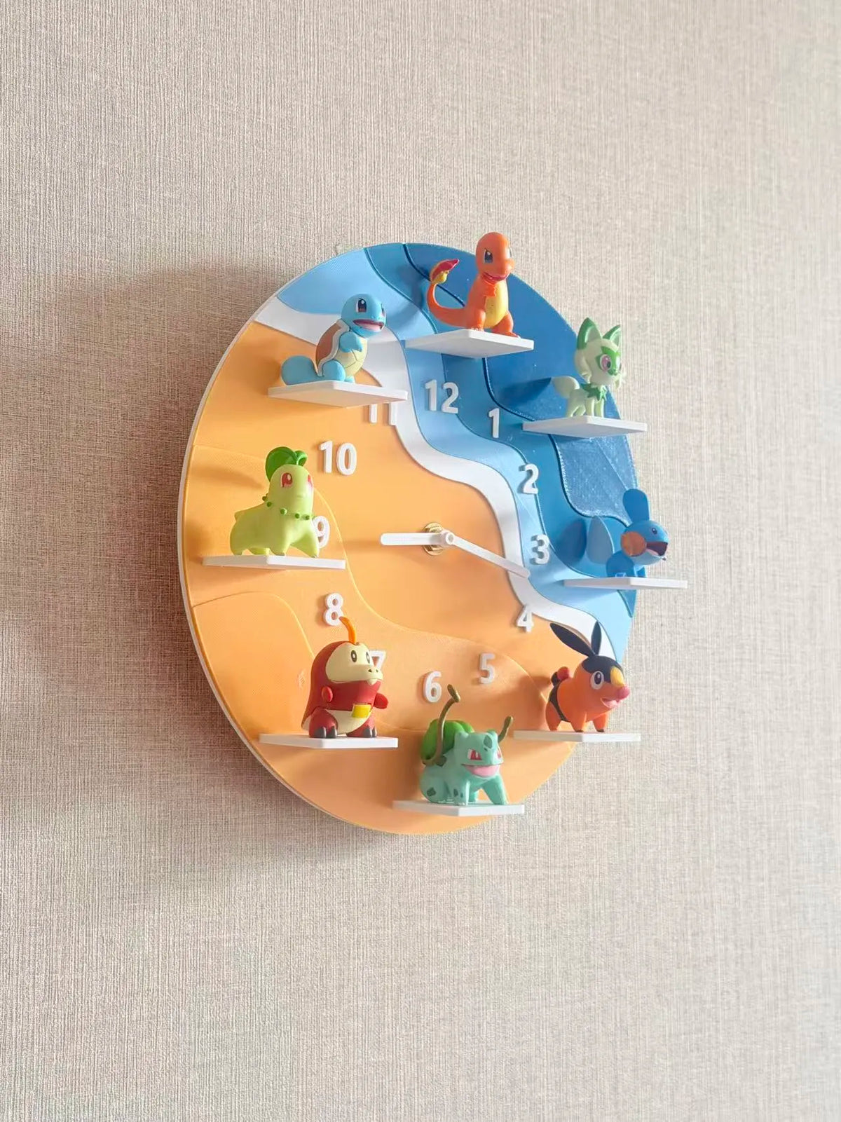 A whimsical 3D wall clock featuring colorful cartoon animal characters positioned around the numbers, with a split orange and blue design, mounted on a textured beige wall.