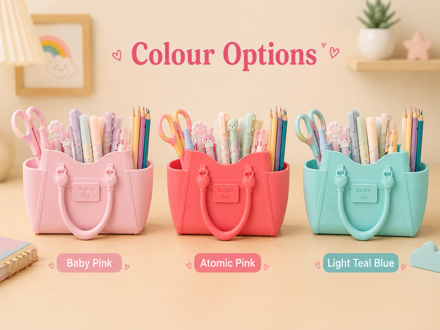 Three tote-style pencil holders in pastel color options labeled Baby Pink, Atomic Pink, and Light Teal Blue, each filled with colorful pencils and stationery, under the heading 'Colour Options' on a soft beige desk setup.