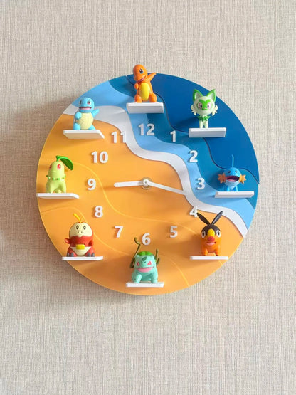 A circular wall clock featuring colorful Pokémon characters placed on white shelf-like platforms instead of traditional hour markers. The clock face is split into blue and orange sections with a white winding river-like divider, and the hands are white.