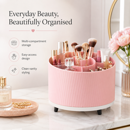 A pink cylindrical vanity organizer with multiple compartments, shown on a marble surface with cosmetics inside. The image includes marketing text on the left and decorative props including flowers, a perfume bottle, and a mirror.