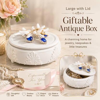 A white embossed decorative giftable antique box with a lid, shown open with jewelry inside. The scene includes promotional text reading 'Large with Lid Giftable Antique Box' and 'A charming home for jewelry, keepsakes & little treasures,' plus a small inset showing the box closed and styled with flowers and ribbon.
