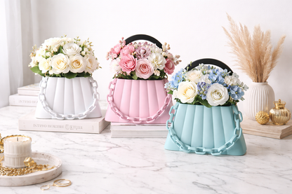 Three decorative vases with floral arrangements on a white surface.