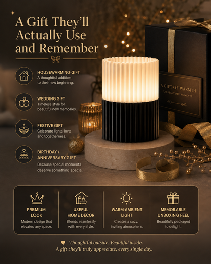 A warm white ribbed cylindrical lamp with a black base sits on a stone pedestal in a cozy, dark decorated room. Large promotional text reads 'A Gift They'll Actually Use and Remember' with icons for housewarming, wedding, festive, and birthday/gift use.
