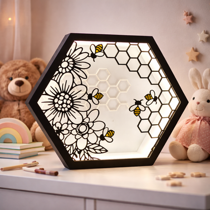 Hexagonal light panel with floral and bee design on a surface with toys and stationery items.