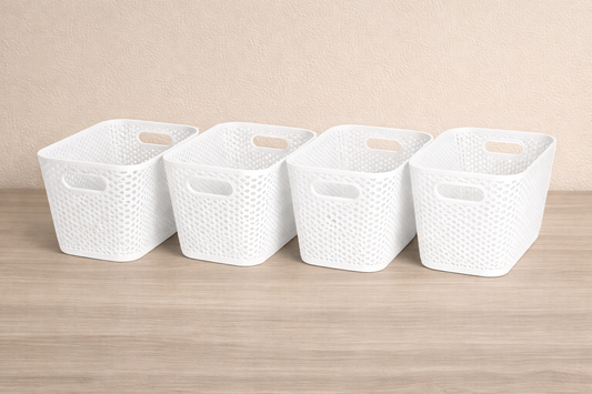 Four white woven storage baskets on a wooden surface with a beige background