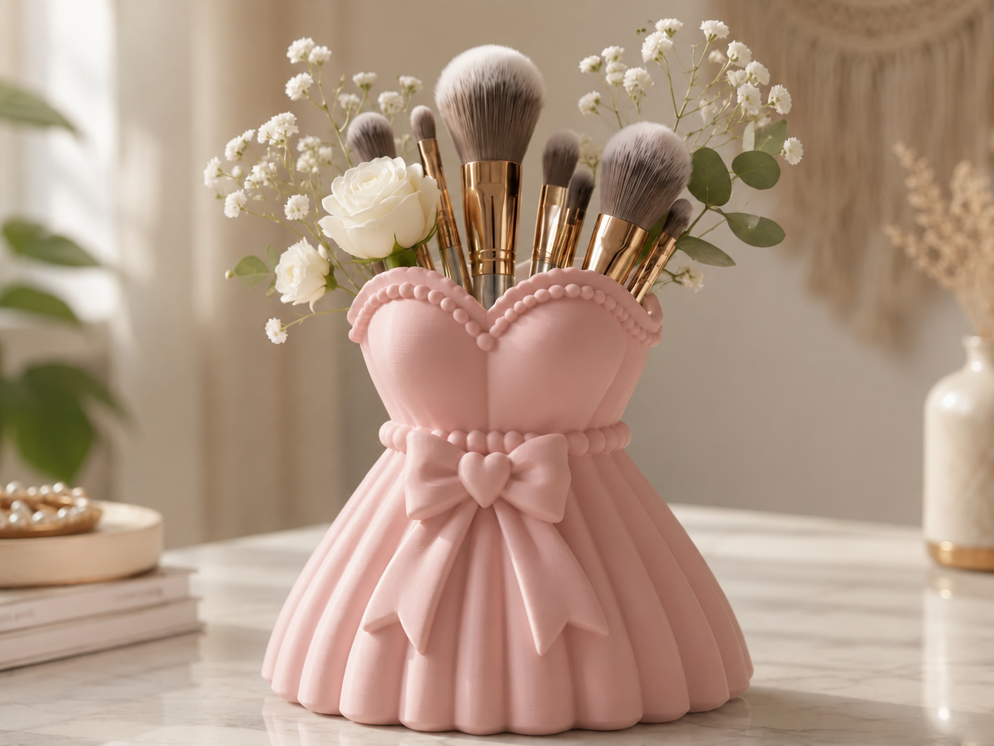 A pink makeup brush holder shaped like a dress, filled with makeup brushes and small white flowers, displayed on a light marble surface in a softly styled interior setting.