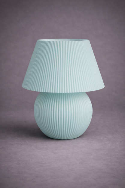 Mint green table lamp with ribbed shade on a gray background