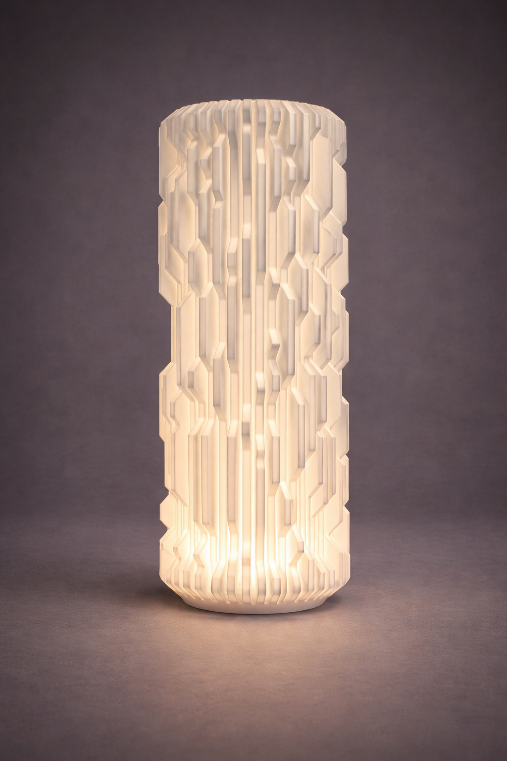 Cylindrical textured lamp with warm glow on a dark background
