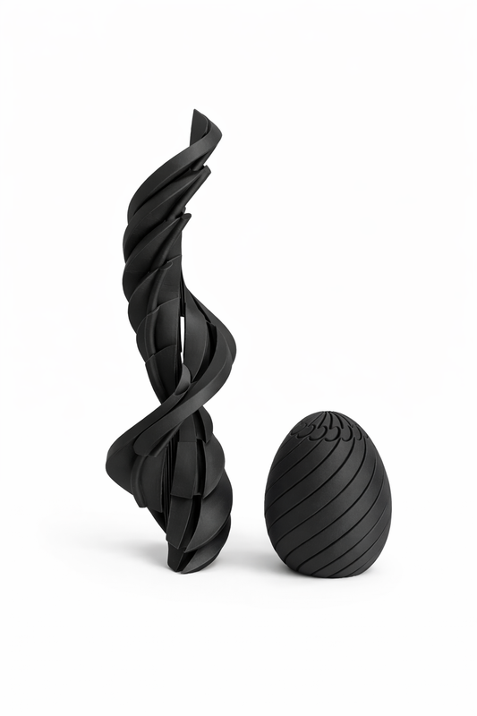 Black twisted sculpture and egg-shaped object on a white background