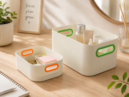 Two cream-colored plastic organizer bins with colorful handles, shown on a wooden desk with various cosmetic and stationery items.