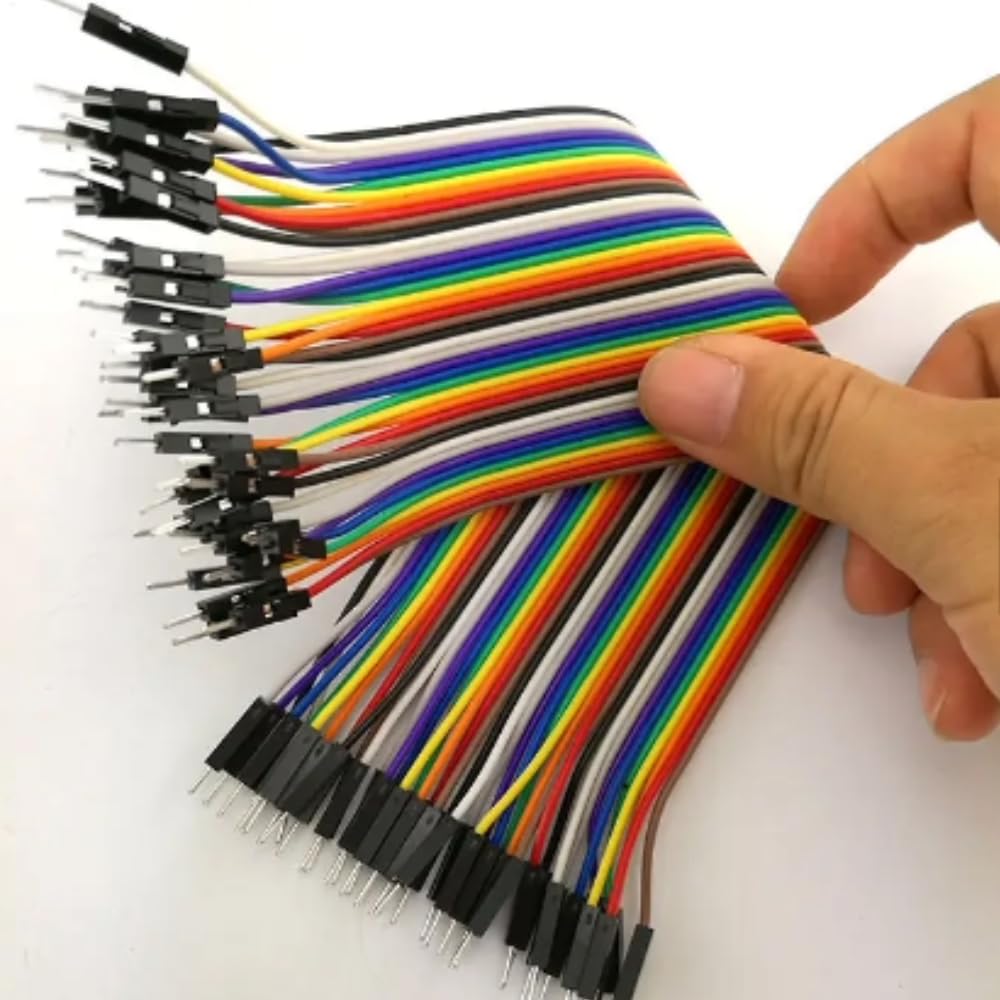 Set of multicolored jump wires held by a hand on a white background