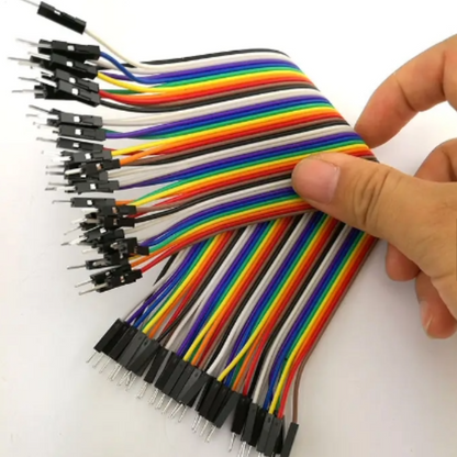 Set of multicolored jump wires held by a hand on a white background