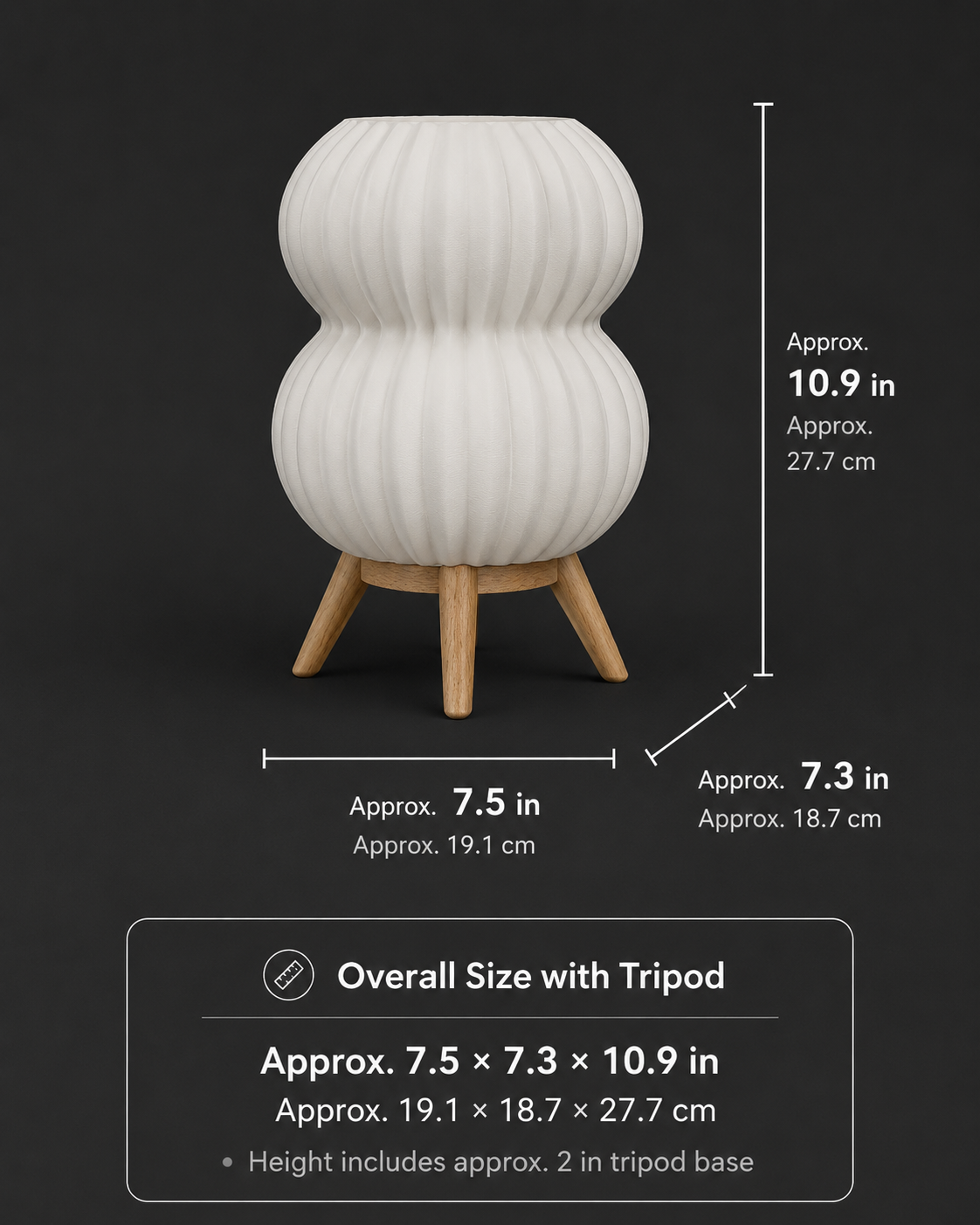 A white ribbed vase-shaped planter with a wooden tripod base on a dark background, with overlaid dimension lines and text showing approximate height, width, and base width in inches and centimeters.