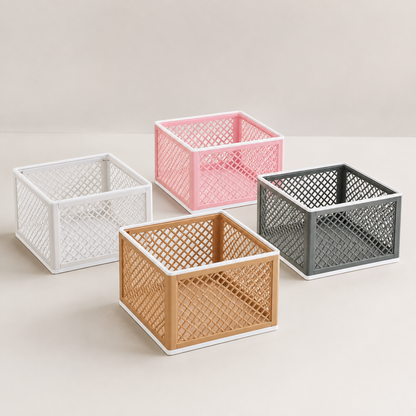 Four square plastic storage baskets with open lattice sides, shown in white, pink, gray, and tan on a light beige background.