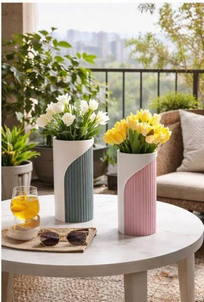 Two flower vases with flowers on a table outdoors