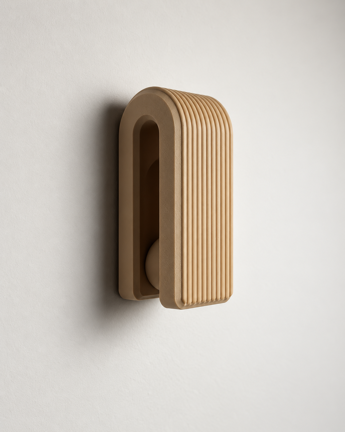 A modern wall-mounted sconce with a ribbed, fluted front and a U-shaped backplate, finished in a warm light brown wood or wood-look material against a plain off-white wall.