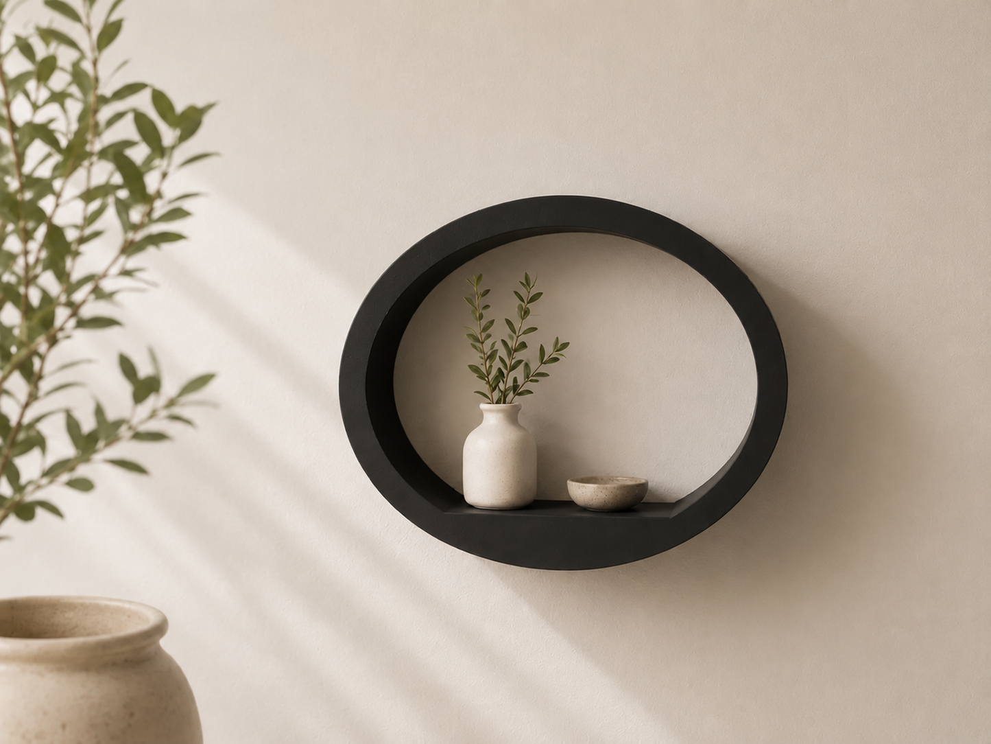 Black round ShapeScape geometric floating wall shelf styled with ceramic vase and bowl