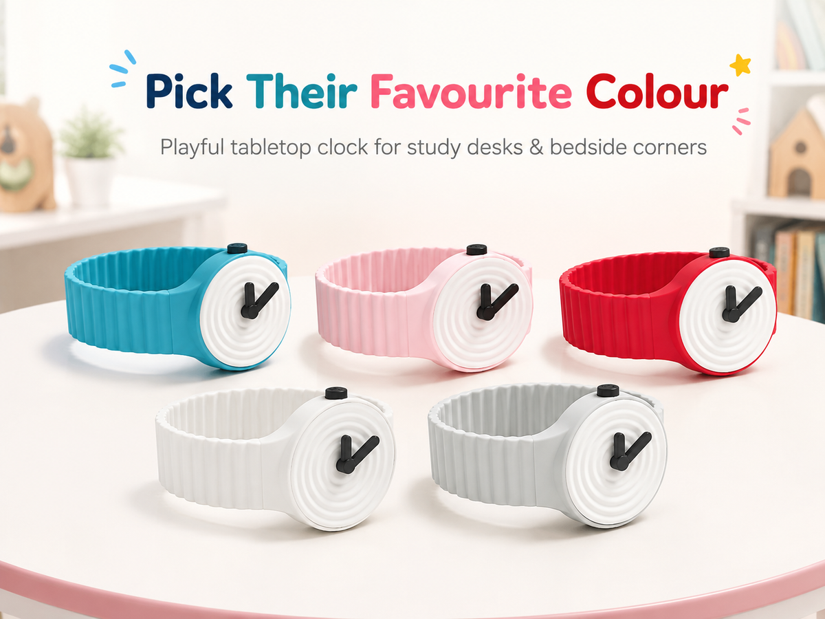 Five silicone wristwatch-style desk clocks in blue, pink, red, white, and light gray are arranged on a round white table. Above them, text reads 'Pick Their Favourite Colour' and 'Playful tabletop clock for study desks & bedside corners.