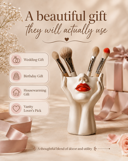 A beige ceramic makeup brush holder shaped like a female face with red lips, holding several makeup brushes. The image is a styled promotional graphic with pink ribbons, gift boxes, baby's breath flowers, and text overlays suggesting gift occasions: Wedding Gift, Birthday Gift, Housewarming Gift, and Vanity Lover's Pick.
